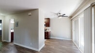 Located at Lavender Common in Fremont, CA, this single-story unit offers a well-organized layout with a practical mix of finishes throughout. The open living area features wood-style plank flooring, neutral gray walls, and a ceiling fan, creating a comfortable and functional space. A wall-mounted HVAC unit provides climate control, while a sliding glass door and front entry door allow natural light to fill the room.

The kitchen is well-appointed with rich dark wood cabinetry extending to the ceiling for ample storage, white subway tile backsplash, light countertops, and a full suite of stainless steel appliances including a gas range, microwave, refrigerator, and sink. The wood-style flooring continues seamlessly from the living area into the kitchen.

The bedrooms are carpeted and feature neutral walls with windows that bring in natural light and views of surrounding greenery. An additional room with wood-style flooring provides flexible use as an office or den.

The bathroom is clean and functional, featuring a tub-shower combination with white tile surround, dark wood vanity with a white countertop, and wood-style flooring that ties the space together cohesively.