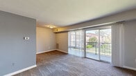 Located at 5237 Marlboro Pike in Capitol Heights, MD, this 2-bedroom, 1-bathroom residence offers a practical and comfortable single-floor layout. The spacious living room is a standout feature, showcasing plush wall-to-wall carpeting, neutral-toned walls with a contrasting accent wall, and large sliding glass doors that flood the space with natural light and provide direct access to a private balcony overlooking greenery and neighboring buildings. The open sightlines between the living room and kitchen create a connected, airy feel. The kitchen is equipped with warm wood cabinetry and a full appliance suite, offering ample functionality. The generously sized primary bedroom features carpet flooring, a wide window with natural light, and convenient closet access. The second bedroom is similarly appointed with carpet, a window with outdoor views, and its own closet. The full bathroom is finished with large-format beige tiles, a decorative mosaic accent border, and a combined tub and shower with chrome fixtures. A hallway connects the key areas of the home efficiently. Neutral paint tones and consistent flooring throughout give the space a cohesive, clean aesthetic suited for comfortable everyday living.