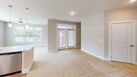 This thoughtfully designed 2-bedroom, 2-bathroom residence in Charlotte, NC offers a comfortable and modern single-floor layout. The open-concept kitchen and living area serves as the heart of the home, featuring white shaker cabinetry, a subway tile backsplash, stainless steel appliances, and a granite-topped peninsula illuminated by stylish pendant lighting. The peninsula includes a built-in sink, making it both functional and a natural gathering point. The living area is generously sized with plush carpet flooring and benefits from abundant natural light through large windows and French doors that open to the exterior. Both bedrooms are carpeted and well-proportioned, with the primary bedroom offering a walk-in closet equipped with wire shelving systems for organized storage. The primary bathroom impresses with a dual-sink granite vanity, wood-look flooring, and a separate glass-enclosed shower. The second bathroom features a full tub-shower combination with granite countertops. A dedicated laundry room accommodates a full-size washer and dryer. Throughout the home, neutral warm-toned walls, recessed lighting, and wood-look flooring in the wet areas contribute to a clean, cohesive aesthetic that is both functional and inviting.