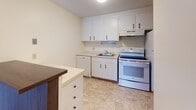 Located at 48 Grove Ave in Leominster, Massachusetts, this single-floor unit offers a practical and comfortable layout designed for everyday living. The kitchen is well-equipped with white cabinetry providing ample storage, a full suite of white appliances including an electric range, dishwasher, and refrigerator, a single-basin sink, and light tile flooring. A dark-topped island or breakfast bar adds additional counter space and a functional workspace.

The living area is generously proportioned, featuring neutral wall-to-wall carpeting and a sliding glass door that opens to an outdoor balcony, allowing natural light to fill the room and offering views of surrounding trees. The open layout creates a welcoming and versatile space. An entry area features warm wood-toned interior doors, a louvered closet for additional storage, and direct access to the kitchen.

The bedrooms are carpeted and bright, with large windows framing natural outdoor views and baseboard heating for year-round comfort. The bathroom includes a full soaking tub with a tiled surround, mosaic tile flooring, and an over-toilet storage cabinet for added organization. Throughout, the unit maintains a clean, neutral palette that provides a move-in ready foundation for personalization.