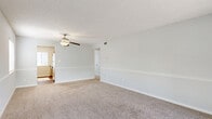 Located on Manatee Ave W in Bradenton, Florida, this single-floor, 3-bedroom, 1-bathroom home offers a functional and well-organized layout. The living room is a standout space, featuring soft carpeting, a ceiling fan with light fixture, a decorative chair rail, and a large sliding glass door that fills the room with natural light and provides access to an outdoor balcony area with views of surrounding greenery.

The galley-style kitchen is equipped with warm wood cabinetry, light countertops, a stainless steel dishwasher, an electric range, and hardwood-style flooring. A window above the counter brings in additional natural light, making the space feel bright and practical.

The three bedrooms are carpeted and painted in soft neutral tones, each featuring windows with horizontal blinds that allow for adjustable natural light. The primary bedroom offers a comfortable amount of space, while all rooms connect via a carpeted hallway lined with panel doors and ample access to closets.

The bathroom includes a full tub-shower combination with white tile surround, a shower curtain, and clean, simple finishes. Throughout the home, textured ceilings, consistent neutral wall tones, and white trim and baseboards create a cohesive and clean aesthetic.