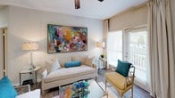 This single-floor residence offers a thoughtfully designed layout that balances comfort and functionality. The open-concept living area is bright and welcoming, featuring wood-look flooring, a ceiling fan, and large windows that allow natural light to fill the space. A bold, colorful abstract artwork anchors the living room, which flows seamlessly into a dedicated dining area with its own decorative accent piece, creating a cohesive entertaining space.

The kitchen is well-equipped with stainless steel appliances, including a refrigerator, range, and over-the-range microwave. White shaker-style cabinetry, granite-look countertops, and a classic subway tile backsplash lend a clean, modern aesthetic.

The residence includes multiple bedrooms, each finished with plush carpeting and soft, neutral wall tones. The primary bedroom is generously sized and features a walk-in closet with built-in shelving, natural light from a large window, and ample room for substantial furniture. Additional bedrooms are equally comfortable and versatile.

Both bathrooms are finished consistently, featuring granite-look vanity countertops, white cabinetry, wood-look tile flooring, and a tub-shower combination. The overall design throughout the residence is cohesive, clean, and move-in ready.