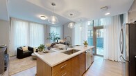 Located in the heart of Philadelphia's Rittenhouse Square neighborhood, this single-floor, 2-bedroom, 2-bathroom residence offers a thoughtfully designed open-concept layout with modern finishes throughout. The living area is bathed in natural light from expansive floor-to-ceiling windows draped in sheer curtains, creating a bright and airy ambiance with views of the surrounding cityscape. The kitchen features a large central island with quartz countertops, warm wood cabinetry, stainless steel appliances, a tile backsplash, and pendant lighting — seamlessly connecting to the living space. The spacious primary bedroom includes dramatic floor-to-ceiling windows overlooking a private outdoor rock garden, offering a tranquil urban retreat. The en-suite primary bathroom is elegantly appointed with large-format marble-style tile, a glass-enclosed walk-in shower, a dual-sink vanity with backlit mirrors, and sleek gray cabinetry. The second bathroom features a soaking tub with marble-style tile surround. A dedicated walk-in closet provides ample built-in storage. The hallway doubles as a curated gallery wall. Light hardwood flooring flows throughout, tying the residence together with a clean, contemporary aesthetic.