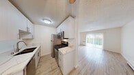Located at 910 Camino Pescadero in Goleta, California, this one-bedroom, one-bathroom residence offers a well-organized and functional single-floor layout. Throughout the unit, light wood-style flooring lends a clean, cohesive aesthetic that pairs well with the crisp white walls and textured ceilings.

The living room is an open, airy space filled with natural light streaming through sliding glass doors fitted with vertical blinds. A ceiling fan, baseboard heating, and a front entry door with a decorative glass insert add both comfort and character to the room.

The bedroom is generously sized, featuring a large window that frames views of the surrounding greenery, including lush palm trees and garden foliage. Baseboard heating and ample wall space provide practical comfort and flexibility for furnishing.

The bathroom is thoughtfully finished with warm beige tile surrounding a full soaking tub and shower combination. A built-in niche in the tile surround offers convenient storage, while the wood-style floor tile, white vanity with under-cabinet storage, and a frosted privacy window complete the well-appointed space.

The exterior of the building is set among mature trees and landscaping, with a balcony visible on the structure and a green hedge boundary offering a sense of privacy. The surrounding Goleta neighborhood provides easy access to local amenities and the natural beauty of the California coast.