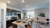 This single-floor residence offers a thoughtfully designed open-concept layout that seamlessly connects the kitchen, dining, and living areas. The kitchen is a standout feature, equipped with dark espresso cabinetry, stainless steel appliances including a refrigerator, electric range, and microwave, as well as a granite-topped island with seating — ideal for casual dining or entertaining. A white subway tile backsplash adds a clean, modern touch, while recessed lighting illuminates the space effectively. Wood-look plank flooring runs throughout, lending a warm, cohesive aesthetic to the entire residence. The dining area is positioned near a large window dressed with sheer curtains, allowing natural light to flow freely into the space. The living room features a ceiling fan and French doors that open to the outdoors, enhancing the connection to natural light and exterior views. The bedroom is generously sized with a ceiling fan, natural light from a window with decorative curtains, and direct access to a walk-in closet with built-in hanging storage. The full bathroom features a dark vanity with granite countertop, wood-look flooring, and a shower-tub combination. A dedicated laundry area with washer and dryer hookups is conveniently accessible from the kitchen corridor.
