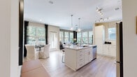Located at 2116 Pleasant Road in Fort Mill, SC, this well-appointed 2-bedroom, 2-bathroom single-floor home offers a thoughtfully designed open-concept layout. The entryway features light hardwood-style flooring, recessed lighting, and a built-in mudroom area with wall hooks — a practical and welcoming introduction to the home.

The kitchen is a standout, showcasing white shaker cabinetry, a classic subway tile backsplash, light stone countertops, stainless steel appliances, and a large center island with seating — illuminated by globe pendant lights and track lighting. The kitchen flows seamlessly into the dining and living areas, which are bathed in natural light from an expansive bank of windows overlooking lush greenery. The living room features a ceiling fan and access to an outdoor area.

The spacious primary bedroom is carpeted with a ceiling fan and large windows, while the second bedroom offers similar comfort with views of the surrounding trees. The primary bathroom features a lengthy double-vanity with stone countertops, white cabinetry, and marble-style tile flooring. The second bathroom includes a tub/shower combination, a single vanity, and matching marble-style tile. A dedicated closet completes this well-organized home.