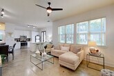Located along Piedmont Road in Atlanta, GA, this 2-bedroom, 3-bathroom residence delivers a modern, open-concept design across a single floor. Polished concrete flooring flows seamlessly throughout the main living areas, lending an urban, industrial character to the bright, airy interior.

The open-plan kitchen and living room form the heart of the home. The kitchen is outfitted with white shaker cabinetry, a dark tile backsplash, stainless steel appliances, and a white quartz peninsula with bar seating — ideal for casual dining or entertaining. Track lighting overhead adds focused illumination. A set of black-framed French doors floods the kitchen with natural light and provides exterior access. The adjacent living room benefits from a large bank of windows with views of the surrounding greenery, a ceiling fan, and ample room for comfortable seating.

Both bedrooms are well-proportioned, featuring carpeted or smooth flooring, natural light from dedicated windows, and access to closets. The primary bedroom is a quiet retreat with room for a full bedroom suite. Each of the three bathrooms is clean and functional, with white tile, soaking tub/shower combinations, and white vanities with modern hardware. The unit also includes two closets for additional storage.