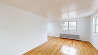 Located at 29 Iozia Terrace in Elmwood Park, NJ, this 2-bedroom, 1-bathroom residence offers a thoughtfully arranged single-floor layout with a clean, bright aesthetic throughout. Warm-toned hardwood floors run continuously through the living areas and bedrooms, lending a cohesive and inviting character to the home.

The living room is a generously proportioned space featuring large windows that allow natural light to fill the room, complemented by a classic cast-iron radiator. The primary bedroom is a comfortable, well-sized room with dual windows offering outdoor views of the surrounding neighborhood, and its own radiator for individual climate control. The second bedroom is similarly bright, with a window and hardwood flooring consistent with the rest of the home.

The kitchen is efficiently designed with white cabinetry, light vinyl flooring, and a full suite of stainless steel appliances including a gas range, microwave, and refrigerator. The bathroom is finished in clean white tile, featuring a full soaking tub with a shower, a window for ventilation, and a white vanity.

A hallway connects the rooms, and an impressive five closets are distributed throughout the unit, providing exceptional storage. A staircase is also present, offering convenient access to building common areas.