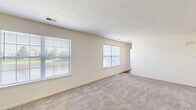 Located at 3814 Burberry Dr in Lafayette, Indiana, this single-floor, 2-bedroom, 2-bathroom home offers a practical and comfortable layout. The living area is finished with neutral-toned carpet and features multiple windows fitted with blinds, allowing natural light to fill the space. A textured ceiling adds subtle character throughout the main living areas. The kitchen is a functional highlight, showcasing rich dark-cherry cabinetry, dark granite-style countertops, hardwood-style flooring, and a full suite of black appliances including a refrigerator, dishwasher, electric range, and microwave. The primary bedroom is generously sized, featuring hardwood-style flooring, a ceiling fan with light fixture, and a sliding glass door that opens to an outdoor area, bringing in additional natural light. The second bedroom is carpeted with a textured ceiling and a window overlooking the outdoors. Both bathrooms are clean and functional, with one featuring a full tub-shower combo. The dedicated laundry room includes an in-unit washer and dryer, a built-in countertop workspace, wire shelving, and hardwood-style flooring—providing excellent utility. A dedicated closet completes the thoughtful layout of this well-appointed home.