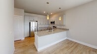Located in Dallas, TX, this single-floor residence offers a thoughtfully designed layout that maximizes comfort and functionality. The open-concept living, dining, and kitchen area serves as the heart of the home, featuring light wood-style flooring that flows seamlessly throughout. The modern kitchen is a standout, equipped with stainless steel appliances, a spacious granite-topped island with a built-in sink, white shaker-style cabinetry extending to the ceiling, and elegant pendant lighting overhead. A dedicated entrance and hallway lead into the main living space, providing a welcoming transition into the home. The bedroom is a comfortable retreat, finished with plush carpet, a ceiling fan, and windows that allow natural light to fill the room. Multiple closets throughout the unit offer generous storage. The bathroom is clean and contemporary, featuring subway tile surrounding a full soaking tub and shower, a granite-topped vanity with gray cabinetry, and wood-style flooring. A dedicated laundry space and a private balcony round out the offerings, adding everyday convenience and an opportunity to enjoy the outdoors. Neutral tones and modern finishes throughout lend the space a fresh, cohesive aesthetic.