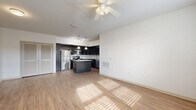 Located at 932 Freedom Way in Brooksville, FL, this single-story, 3-bedroom, 2-bathroom home offers a well-designed layout with consistent wood-style flooring and a neutral color palette throughout. The open-concept kitchen and living area serves as the heart of the home, featuring dark espresso cabinetry, granite countertops, a subway tile backsplash, and a full suite of stainless steel appliances including a gas range, microwave, refrigerator, and dishwasher. A central kitchen island with a granite surface provides additional prep and dining space, while pendant and track lighting add a modern touch overhead. Ceiling fans are present in the living area and bedrooms, promoting year-round comfort. Each of the three bedrooms is well-proportioned, with the primary bedroom offering generous space, and all rooms feature windows with blinds that allow for natural light and outdoor views. The two bathrooms are finished with light tile flooring and surround, dark vanity cabinetry, and granite countertops, each equipped with a tub-shower combination. Four closets provide ample storage throughout the home. A hallway connects the bedroom wing, contributing to a functional and organized floor plan.