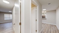 This single-floor residence in Manchester, Connecticut offers a thoughtfully updated interior with a cohesive, contemporary design. Light-toned luxury vinyl plank flooring runs throughout the main living areas and bedrooms, complementing the neutral warm-beige walls and crisp white trim that define the space's clean aesthetic.

The living area is generously proportioned, featuring a vaulted ceiling with a circular skylight and a sliding glass door that fills the room with natural light and provides outdoor access. Adjacent to the living space, the kitchen is well-appointed with white shaker-style cabinetry, quartz countertops, a grey subway tile backsplash, and a full suite of stainless steel appliances including a gas range, built-in microwave, refrigerator, and dishwasher.

The hallway connects the bedrooms and features panel-style closet doors offering ample storage. Bedrooms are bright and neutral, with at least one featuring a window with exterior views. The bathrooms are finished with marble-style tile surrounds, white vanities with updated fixtures, and grey stone-look floor tile. A dedicated laundry area houses a stacked washer and dryer, adding everyday convenience to this move-in-ready home.
