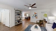 Located at 3720 W Alabama St in Houston's desirable Galleria neighborhood, this well-appointed 2-bedroom, 2-bathroom residence offers a thoughtfully designed single-level layout. Light wood-style flooring flows throughout the open-concept living, dining, and kitchen areas, creating a cohesive and inviting atmosphere.

The kitchen is a standout feature, equipped with stainless steel appliances including a refrigerator, electric range, and over-the-range microwave. Crisp white shaker cabinetry, white quartz countertops, a subway tile backsplash, and a double-basin sink with peninsula seating complete this functional and stylish space.

The living room is bright and comfortable, featuring a ceiling fan, wall-mounted display shelving, and sliding glass doors that open to a private balcony with outdoor views. The adjacent dining area offers crown molding and track lighting.

Both bedrooms include ceiling fans and generous natural light from large windows. The primary bedroom connects to its own bathroom, while a second full bathroom serves the additional bedroom. Each bathroom features a tub/shower combination with white tile surround.

A dedicated in-unit laundry room houses a full-size Whirlpool washer and dryer. Two closets provide ample storage throughout the residence.