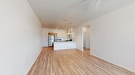 Located at 4254 N Fourth Ave in Tucson, Arizona, this single-story, 3-bedroom, 3-bathroom home offers a clean, modern layout designed for comfortable everyday living. The open-concept living and kitchen area serves as the heart of the home, featuring light wood-look flooring that flows throughout, recessed lighting, and a chandelier that adds a refined touch. The kitchen is well-appointed with two-tone cabinetry — warm wood lower cabinets paired with crisp white uppers — light stone countertops, a full suite of stainless steel appliances including a refrigerator, gas range, and microwave, and a peninsula that provides additional prep and dining space. The spacious primary bedroom spans a generous footprint and is filled with natural light from a large window, complemented by a ceiling fan and access to a walk-in closet outfitted with multi-tiered shelving on all sides. The three bathrooms include tub/shower combinations with clean white surrounds and wood-look tile flooring. A dedicated laundry room houses a full-size front-loading washer and dryer. The attached garage features a windowed door that allows natural light into the concrete-floored space. Throughout the home, the bright white walls and consistent flooring create a cohesive, light-filled atmosphere.