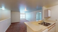 Located at 783 29th St NW in Roanoke, Virginia, this single-floor residence offers a practical and straightforward layout designed for comfortable everyday living. The open-concept kitchen and living area serves as the heart of the home, where a peninsula with a stainless steel sink and light countertops connects the kitchen space to the carpeted living area beyond. The kitchen is well-equipped with white cabinetry, ample overhead storage, a double-basin sink, an electric coil range, a refrigerator, and a dishwasher, all set atop wood-look vinyl flooring that adds warmth and durability to the space.

The living area flows naturally into an additional carpeted room separated by a half-wall partition, providing flexible space that could accommodate a variety of uses. Multiple bedrooms throughout the unit share a consistent design featuring wall-to-wall carpet, neutral walls, and windows fitted with blinds that invite natural light and outdoor views.

Two bathrooms serve the residence. The larger bathroom includes a tub-shower combination, a vanity with a sink and under-sink storage, and tile-look flooring. A second bathroom offers a similarly clean design with a single-sink vanity, a large mirror with overhead lighting, and wood-look flooring. Together, the spaces present a clean, functional environment suited for single-floor living.