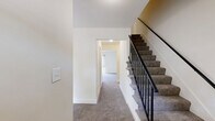 This three-story home in Columbia, MD offers six bedrooms and four bathrooms across three well-proportioned floors, providing ample space for a variety of living arrangements. The layout is thoughtfully distributed, with each level offering a comparable footprint connected by carpeted staircases with sleek black metal railings.

The kitchen features rich wood cabinetry, dark granite-style countertops, a stainless steel sink, and hardwood-style flooring, opening directly into a carpeted living area filled with natural light from a large sliding glass door. Additional sliding glass doors are found in select rooms, offering outdoor views and direct patio access.

The bedrooms are carpeted throughout and finished with neutral tones, creating a clean and versatile environment. The spacious primary bedroom includes closet access and ample room to accommodate a variety of configurations. Secondary bedrooms feature built-in sliding-door closets, providing practical storage. Hallways connect the rooms across all three floors, contributing to an efficient and accessible flow.

The four bathrooms are consistently appointed with white tile tub-shower combos, wood-toned vanities with white countertops, and large mirrors. A utility room and additional closet space round out the home's functional offerings. The bright, neutral palette throughout lends the home a clean, move-in-ready character.