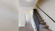 This three-story home in Columbia, MD offers six bedrooms and four bathrooms across three well-proportioned floors, providing ample space for a variety of living arrangements. The layout is thoughtfully distributed, with each level offering a comparable footprint connected by carpeted staircases with sleek black metal railings.

The kitchen features rich wood cabinetry, dark granite-style countertops, a stainless steel sink, and hardwood-style flooring, opening directly into a carpeted living area filled with natural light from a large sliding glass door. Additional sliding glass doors are found in select rooms, offering outdoor views and direct patio access.

The bedrooms are carpeted throughout and finished with neutral tones, creating a clean and versatile environment. The spacious primary bedroom includes closet access and ample room to accommodate a variety of configurations. Secondary bedrooms feature built-in sliding-door closets, providing practical storage. Hallways connect the rooms across all three floors, contributing to an efficient and accessible flow.

The four bathrooms are consistently appointed with white tile tub-shower combos, wood-toned vanities with white countertops, and large mirrors. A utility room and additional closet space round out the home's functional offerings. The bright, neutral palette throughout lends the home a clean, move-in-ready character.