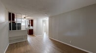 Located at 4706 Yellowstone Blvd in Houston, TX, this single-story, two-bedroom, one-bathroom unit offers a thoughtfully updated interior within a compact, efficiently arranged floor plan. Light-toned wood-look flooring runs throughout the space, contributing to a cohesive and easy-to-maintain aesthetic.

The galley-style kitchen is a standout feature, showcasing rich, warm-toned wood cabinetry extending to the ceiling for generous storage capacity. Granite countertops line both sides of the kitchen, complemented by a stainless steel refrigerator, an electric range, and a single-basin sink. A window at the end of the kitchen allows natural light to filter in.

The living room provides an open, functional layout with a textured ceiling and wood-look flooring, with a hallway connecting to the rest of the unit. Both bedrooms are finished with the same light flooring, neutral wall tones, and horizontal windows that bring in natural light. The primary bedroom includes a ceiling fan and a wall-mounted mini-split HVAC unit. The second bedroom features a closet and a well-lit, minimalist design.

The bathroom is appointed with large-format marble-style wall tile surrounding the tub and shower combination, adding an elevated touch to the space.
