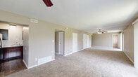 Located at 59 Port Ocall Dr in Indianapolis, Indiana, this single-floor home offers four bedrooms and two full bathrooms. The layout is connected by three hallways, providing a well-organized flow throughout the residence. The generously sized primary bedroom features light hardwood-style vinyl flooring, neutral warm-toned walls, and a ceiling-mounted baseboard heater, with an open passage leading to an adjacent area. The remaining bedrooms are finished with plush carpet, neutral gray-toned walls, and windows that bring in natural light and views of the surrounding greenery. The living area is carpeted and features ceiling fans and large sliding glass doors dressed with vertical blinds, opening to an outdoor view. The kitchen is well-appointed with rich dark espresso cabinetry, light marble-pattern countertops, a black electric range, a stainless steel sink, and a built-in range hood — offering both style and functionality. Both bathrooms include full tub-and-shower combinations; one features white surround paneling with brushed gold fixtures, while the other showcases white tile surround with chrome hardware. Throughout the home, clean white trim, consistent neutral paint, and updated finishes create a cohesive and move-in-ready atmosphere.