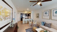 This single-story unit in Conroe, Texas, offers a thoughtfully designed open-concept layout that seamlessly connects the living, dining, and kitchen areas. Wood-style flooring flows throughout the main living spaces, complemented by neutral-toned walls and ceiling fans in both the living room and bedroom.

The kitchen is a standout feature, showcasing dark espresso cabinetry that extends to the ceiling, granite countertops, a subway tile backsplash, and stainless steel appliances including a refrigerator with ice maker, microwave, and range. A peninsula island with granite counters provides bar seating and additional prep space, while pendant lighting above adds a polished finishing touch.

The living area benefits from multiple windows that bring in natural light, and opens directly to a compact dining space. The bedroom is carpeted and features a walk-in closet with built-in shelving, windows with blinds, and direct access to the bathroom. The bathroom is equipped with dark cabinetry, a granite vanity, and a tiled tub-shower combination. The overall design maintains a cohesive, modern aesthetic throughout.