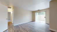 Located at 7413 S Land Park Dr in Sacramento, CA, this single-floor unit offers a well-organized and functional layout throughout. The living area is a standout feature, showcasing durable wood-style flooring that flows seamlessly through the main spaces. A large sliding glass door fitted with vertical blinds fills the room with natural light and provides access to an outdoor area, creating an open and airy atmosphere. The kitchen is efficiently designed with light wood cabinetry, speckled countertops, and includes essential appliances such as a refrigerator, range, dishwasher, and sink — all set on easy-to-maintain wood-style flooring. A peninsula-style counter connects the kitchen to the main living area, offering a practical transition between spaces. The bedroom is generously proportioned, featuring soft carpeting, neutral walls, and a window that invites natural light and outdoor greenery views. The bathroom is clean and practical, with warm wood-toned cabinetry, a wide speckled countertop vanity with an integrated sink, a large mirror, and a tub-shower combination. Textured ceilings and neutral warm-toned walls are consistent throughout, lending a cohesive and calm aesthetic to the entire unit.