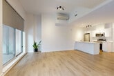 Located at 150 Rue King in Montréal, this well-designed one-bedroom, one-bathroom unit offers a clean, contemporary aesthetic across a single floor. Light-toned hardwood flooring runs throughout, creating a cohesive and airy feel. The welcoming entrance corridor leads past multiple closets, providing ample storage before opening into the main living area.

The open-concept living and dining room is bright and spacious, anchored by large floor-to-ceiling windows that invite natural light and offer views of the surrounding exterior. A wall-mounted mini-split unit ensures year-round climate comfort. The kitchen features white cabinetry, white quartz countertops, stainless steel appliances including a refrigerator, dishwasher, range, and microwave, and is separated from the living area by a practical breakfast bar peninsula.

The bedroom is a comfortable, well-proportioned room with large windows fitted with baseboard heating, light hardwood floors, and a double closet. The bathroom is finished in a crisp all-white palette with large-format floor tiles, a vanity with undermount sink, and a glass-door walk-in shower. The overall design prioritizes clean lines, neutral tones, and functional layout, making this a practical and modern urban residence.