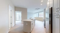 Located in the heart of downtown Cincinnati on Vine Street, this modern 2-bedroom, 2-bathroom residence offers a thoughtfully designed open-concept layout finished with clean, contemporary details throughout. Light hardwood flooring flows seamlessly across the entire space, complementing the bright, neutral color palette that gives the home an airy, welcoming feel.

The kitchen serves as a central hub, anchored by a large island with a quartz countertop and undermount sink. White shaker cabinetry extends floor to ceiling, providing generous storage, while stainless steel appliances — including a French door refrigerator, electric range, built-in microwave, and dishwasher — complete the space. A subtle herringbone tile backsplash adds a refined decorative touch.

The open living area flows naturally from the kitchen and is bathed in natural light from large windows offering striking elevated views of the Cincinnati skyline and surrounding urban landscape. The spacious primary bedroom continues this connection to the city through expansive floor-to-ceiling windows. A dedicated closet provides ample storage. The second bedroom also features large windows with city views and light-toned walls.

Both bathrooms are finished with clean, modern fixtures. The full bath includes a tiled tub/shower surround, a sleek vanity with white cabinetry, and large-format tile flooring. Recessed lighting and a cassette-style HVAC system are featured throughout the home.