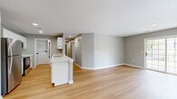 Located in Columbus, OH, this two-bedroom, two-bathroom two-story home offers a well-designed layout with a functional mix of living spaces. The entry level houses an attached garage with a concrete floor and direct interior access, connecting seamlessly to the main living floor via a staircase with wood-look flooring.

The main level is where the majority of the living space resides, featuring an open-concept layout that integrates the dining room, kitchen, and living room into one expansive area. The kitchen is outfitted with white shaker cabinetry, a white quartz countertop peninsula with an undermount sink and a contemporary pull-down faucet, subway tile backsplash, and stainless steel appliances including a refrigerator, electric range, and over-the-range microwave. A dedicated pantry and in-unit laundry area round out the practical conveniences of this floor.

Both bedrooms offer natural light through window treatments, with the primary bedroom featuring plush carpeting and generous proportions. Four closets, including a walk-in with wire shelving, provide ample storage. The two bathrooms are clean and modern, with white vanities, quartz countertops, and light wood-look flooring. A balcony adds an outdoor retreat, completing this well-appointed home.