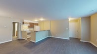 Located at 1406 Brookside Dr in Raleigh, NC, this single-floor unit offers a thoughtfully designed open-concept layout that maximizes both space and functionality. Dark hardwood-style flooring flows throughout the main living areas, providing a cohesive and polished look. The kitchen is positioned at the heart of the unit, equipped with rich medium-toned wood cabinetry, stone-patterned countertops, a white electric range, a refrigerator, and an overhead ventilation hood. A peninsula with a raised countertop separates the kitchen from the living area, offering additional prep and seating space. The expansive living and dining area is bathed in natural light from a large sliding glass door fitted with vertical blinds, offering a view of lush greenery outside. A secondary window in the living space further enhances natural light. The bedroom is generously sized, finished with plush carpet, and features a sliding glass door that opens to outdoor views. It connects directly to a full bathroom, which includes a wood-toned vanity, a standard tub-shower combination, and wood-look tile flooring. Warm neutral wall tones throughout the unit create a welcoming and versatile atmosphere suitable for a variety of living arrangements.