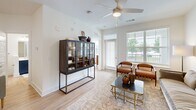 Located at 200 Brooklawn St in Farragut, Tennessee, this thoughtfully designed one-bedroom, one-bathroom residence offers a comfortable and cohesive single-floor layout. The open-concept kitchen and living area serves as the heart of the home, anchored by a large central island with a crisp white quartz countertop and bar seating. The kitchen features a striking two-tone design with bold navy lower cabinets contrasting against white upper cabinetry, complemented by a marble-style tile backsplash and a full suite of stainless steel appliances. Pendant lighting above the island adds a refined touch. Light hardwood-style flooring runs throughout the main living areas, enhancing the sense of openness and flow. The living room is bathed in natural light from large windows and a glass door that opens to a private balcony, with a ceiling fan overhead adding to the airy feel. The bedroom is a serene retreat with a ceiling fan, natural light from a window with outdoor views, and direct access to the closet. The bathroom is clean and functional, featuring navy vanity cabinetry with a white countertop, subway-tiled tub and shower combination, and wood-look flooring. In-unit laundry is also included, adding everyday convenience to this well-rounded Farragut residence.
