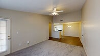 This single-story residence in Robertsdale, Alabama, offers three bedrooms and two full bathrooms within a well-organized, functional floor plan. The living area is a standout feature, distinguished by vaulted ceilings and a ceiling fan with light fixture that enhance the sense of openness. Neutral-toned carpet covers the living space, while hardwood-style flooring extends through the adjoining areas and hallways, creating a clean visual transition throughout the unit.

The kitchen is positioned adjacent to the living area and features a peninsula breakfast bar that connects the two spaces. White cabinetry provides ample storage, and the kitchen is equipped with a coil-burner electric range and a full-size refrigerator. A dining area sits nearby, completing the open-concept arrangement.

A central hallway leads to the three bedrooms, each finished with carpet flooring and neutral wall tones. The primary bedroom includes vaulted ceilings, a ceiling fan, and a large window for natural light. The secondary bedrooms offer comfortable dimensions with windows providing additional daylight.

Both bathrooms include vanities with white cabinetry, single-sink countertops, mirrors, and tub-shower combinations with hardwood-style flooring. The overall aesthetic is clean and straightforward throughout.