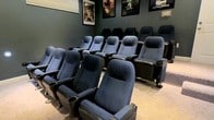 Located at 3655 Rosslare Harbour Dr in Pickerington, Ohio, this single-floor property offers a standout entertainment experience centered around a dedicated home theater room. The theater is designed to replicate the feel of a commercial cinema, featuring multiple rows of plush, stadium-style reclining seats upholstered in navy blue fabric with built-in cup holders — accommodating a generous number of viewers in comfort. The seating is arranged in a tiered layout to ensure unobstructed sightlines from every row. The walls are painted in a deep, dark tone that enhances the immersive viewing atmosphere and minimizes light reflection. Framed movie posters — including titles such as Finding Nemo and Harry Potter — are displayed along the upper walls, adding a classic cinematic character to the space. The overall ambiance of the theater is intimate yet spacious, purpose-built for an authentic movie-going experience without leaving home. The single-level layout of the property ensures easy accessibility throughout. This space is well-suited for movie enthusiasts and entertainers alike, offering a thoughtfully designed environment that prioritizes both comfort and the art of cinematic presentation.