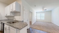 Located at 4115 S Lee St in Buford, Georgia, this 2-bedroom, 1-bathroom single-story home offers a well-organized layout across a comfortable footprint. The galley-style kitchen is a standout feature, outfitted with crisp white shaker cabinetry, granite countertops, a stainless steel sink, and wood-look flooring — providing both style and functionality. It flows conveniently toward the dining area and into the living room, which is brightened by a large window and a ceiling fan overhead.

Both bedrooms are carpeted and filled with natural light from window treatments, with the spacious primary bedroom offering ample room for furnishings. The home includes four closets in total, providing generous storage throughout — including a walk-in closet with multi-tiered wire shelving. The full bathroom features a walk-in shower with a built-in bench and wood-look tile flooring.

A dedicated laundry room with wire shelving adds day-to-day convenience, and multiple utility spaces support practical storage needs. The hallway connects the main living areas to the private bedrooms, creating a logical and efficient floor plan. Clean neutral walls and consistent finishes throughout lend the home a cohesive, move-in-ready aesthetic.