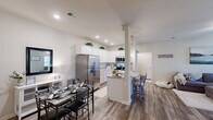 Located at 304 Hannah Todd Pl in Lexington, Kentucky, this single-story 2-bedroom, 2-bathroom home offers a thoughtfully designed layout with modern finishes throughout. The open-concept kitchen and living area serves as the heart of the home, featuring white shaker-style cabinetry, granite countertops, stainless steel appliances, and a central island with bar seating illuminated by pendant lighting. Light wood-tone flooring runs through the main living areas, complementing the neutral color palette and recessed lighting overhead. The adjacent living room is bright and welcoming, with a ceiling fan, large windows that invite natural light, and a comfortable, open feel. A dedicated dining area sits conveniently alongside the kitchen. Both bedrooms are carpeted and well-sized, offering a calm retreat. The primary bedroom includes access to a walk-in closet. Each bathroom features a shower-tub combination with clean, neutral finishes. A dedicated laundry room with overhead shelving and in-unit washer hookups adds everyday convenience. Two closets provide ample storage throughout. The home's efficient single-floor plan and cohesive design make for a functional and inviting living space in a residential Lexington neighborhood.