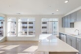 Located at 9420 Grand Blvd in Upper Marlboro, Maryland, this thoughtfully designed 2-bedroom, 2-bathroom residence offers a clean, modern aesthetic across a well-utilized single-floor layout. Light hardwood flooring flows seamlessly throughout the entire space, creating a bright and cohesive atmosphere.

The kitchen is a standout feature, showcasing slate-gray shaker-style cabinetry that extends to the ceiling for maximum storage, a white subway tile backsplash, light countertops, and a full suite of stainless steel appliances including a refrigerator, range, built-in microwave, and dishwasher. Recessed lighting illuminates the space effectively.

A bright hallway with recessed lighting connects the main living areas to the two bedrooms, with natural light visible from a window at the end of the corridor. The primary bedroom offers a comfortable footprint with neutral white walls and good natural light. The second bedroom also features a large window with exterior views, filling the room with daylight.

Both bathrooms are finished with white subway tile tub-and-shower surrounds, light quartz-style countertops, and dark cabinetry vanities, maintaining a consistent modern design language. Additional features include four closets, an in-unit laundry area, and a dedicated electrical panel for resident convenience.