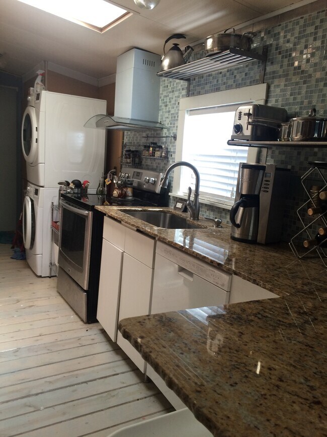 Cocina de planta abierta con fregadero profundo de acero inoxidable y grifo extraíble. Encimeras de granito. - 3000 Clarcona Road