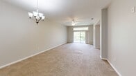Located at 209 Cantabria Way in Saint Augustine, FL, this well-appointed single-story home offers 2 bedrooms and 3 bathrooms across a thoughtfully designed floor plan. The open-concept layout seamlessly connects the kitchen, dining, and living areas, creating an inviting space ideal for both everyday living and entertaining. The kitchen is a standout feature, showcasing rich wood cabinetry, dark granite countertops, large-format white tile flooring, and a full suite of stainless steel appliances, including a refrigerator with ice maker and a built-in oven. Recessed lighting illuminates the space throughout. The combined living and dining area is generously proportioned, finished with neutral-toned carpet and accented by a ceiling fan and an elegant chandelier. Sliding glass doors lead to a private balcony, filling the space with natural light and outdoor views. Both bedrooms are carpeted and feature windows with blinds that allow for natural light, along with ceiling fans for comfort. The primary bedroom is spacious and well-sized. Three clean, functional bathrooms include a tiled tub-shower combination. A dedicated laundry room houses a full-size washer and dryer. Neutral paint tones and clean finishes throughout lend the home a calm, move-in-ready aesthetic.