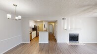 Located at 222 Kyser Blvd in Madison, Alabama, this single-floor 2-bedroom residence offers a clean, modern aesthetic with thoughtfully updated finishes throughout. The open-concept living area is anchored by a tiled fireplace and features warm wood-look flooring, a ceiling fan, and a sliding glass door that invites natural light and outdoor access. The kitchen is a standout, outfitted with crisp white shaker cabinetry, granite countertops that extend to a peninsula breakfast bar, stainless steel appliances including a refrigerator and dishwasher, and a undermount sink — all beneath a textured ceiling with flush lighting. A hallway connects the main living spaces to the two bedrooms, each carpeted for comfort and equipped with ceiling fans. The primary bedroom includes a private en-suite bathroom featuring granite countertops, a large vanity mirror, wood-look flooring, and a tiled tub/shower combination. A second full bathroom serves the remaining bedroom. Neutral gray tones and white trim create a cohesive, move-in-ready feel throughout the entire residence.