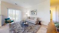 Located at 14205 Maple Tree Ln in East Lyme, Connecticut, this single-floor residence offers a thoughtfully designed interior with a clean, contemporary aesthetic throughout. The layout flows naturally between living, dining, and kitchen areas, creating a cohesive and functional living environment.

The living room features soft carpeting, neutral walls, and a sliding glass door with vertical blinds that invites natural light and provides outdoor views. The galley-style kitchen is well-appointed with white shaker cabinetry, granite-look countertops, stainless steel appliances, and wood-look flooring, complemented by a window that brings in additional daylight. Adjacent to the kitchen, the dining area is surrounded by multiple windows overlooking greenery, creating a bright and airy atmosphere ideal for everyday meals.

The bedrooms are carpeted and bathed in natural light from generously sized windows with outdoor views. One flexible room serves well as a home office or den, featuring its own window and double closet doors for ample storage. Two full bathrooms are present—one with a soaking tub and one with a glass-enclosed shower—both featuring dark-toned vanities, wood-look flooring, and clean white finishes throughout.