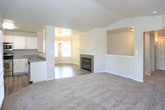 This single-floor residence at 9500 Osuna Rd NW in Albuquerque, New Mexico, offers a well-designed open-concept layout that seamlessly connects the living, dining, and kitchen areas. The living room features plush carpeting, vaulted ceilings, and large windows with blinds that invite an abundance of natural light, creating a bright and welcoming atmosphere. A direct-access exterior door provides convenient outdoor connectivity.

The kitchen is thoughtfully appointed with white shaker-style cabinetry, speckled granite-look countertops, and a full suite of stainless steel appliances, including a refrigerator, range with oven, over-the-range microwave, and dishwasher. Wood-look flooring runs throughout the kitchen and dining area, while a chandelier adds an elegant touch to the dining space.

The spacious bedrooms are carpeted and filled with natural light through large windows, with one room featuring crown molding and a ceiling fan. A generously sized bedroom offers walk-in closet access nearby.

Two full bathrooms are finished with white cabinetry, speckled countertops, and wood-look flooring. The primary bathroom features a soaking tub, tiled shower surround, extended vanity with a wide mirror, and access to a walk-in closet. The secondary bathroom mirrors the clean, functional aesthetic with a tub-shower combination. A fireplace is also visible in the main living area, adding warmth and character to the home.