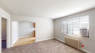 Located at 4219 Allendorf Dr in Cincinnati, Ohio, this single-floor unit offers a straightforward, functional layout designed for comfortable everyday living. The floor plan reveals several interconnected rooms, including a living area, kitchen, bedrooms, and a full bathroom, all arranged for practical flow and accessibility.

The living and bedroom areas are finished with neutral-toned wall-to-wall carpeting, contributing to a warm and quiet atmosphere. Each carpeted room is equipped with a classic cast-iron radiator, providing reliable radiant heat, along with windows fitted with horizontal blinds that allow for natural light control. Ceiling fans are present in the bedroom spaces, adding to year-round comfort.

The kitchen features a galley-style configuration with warm wood-toned cabinetry lining both sides, offering generous upper and lower storage. A double-basin stainless steel sink, laminate countertops, a white refrigerator, and a dishwasher complete the space. Light tile flooring extends through the kitchen, providing a clean contrast to the carpeted rooms. A window at the end of the kitchen brings in additional natural light.

The bathroom is finished with white tile surrounding a full tub-and-shower combination, complemented by a pedestal sink and a frosted glass window, maintaining brightness while ensuring privacy.