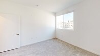 Located at 1446 Tamarind Ave in the heart of Hollywood, Los Angeles, this modern single-floor unit offers a clean, contemporary design throughout. The open-concept living area features light wood-style flooring, crisp white walls, and track lighting, creating a bright and airy atmosphere. A sliding glass door leads to a private balcony, allowing natural light to pour in while offering views of the surrounding neighborhood, including glimpses of palm trees that define the Southern California landscape.

The kitchen is thoughtfully designed with warm wood cabinetry, white quartz countertops, a stainless steel sink, and a full suite of stainless steel appliances including a gas range, microwave, and refrigerator. A peninsula counter connects the kitchen to the living space, making it ideal for both cooking and entertaining.

The bedrooms are carpeted for comfort, featuring white walls and windows that invite natural light. The bathroom is finished to a high standard, showcasing large-format tile flooring, a tub-shower combination enclosed by sliding glass doors with striking marble-style tile surround, a wood-toned vanity, and a wall-mounted mirror. The overall aesthetic is clean, modern, and move-in ready.