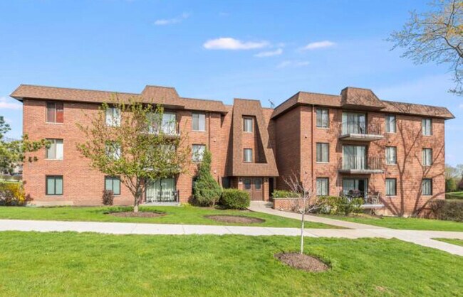 Main condo building entranceway. Beautifully manicured landscaping all around the property - 80 S Pleasant Rd