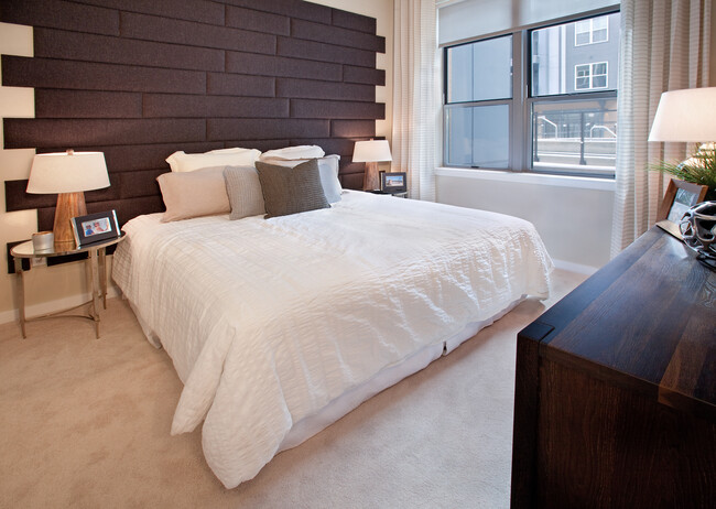 Bedroom with accent wall and carpet - Avalon Potomac Yard