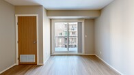 Located in the Skyview Ranch community of Calgary, AB, this well-appointed 3-bedroom, 2-bathroom unit offers a practical and comfortable layout across a single floor. The open-concept kitchen and living area forms the heart of the home, featuring light wood laminate flooring, white cabinetry with sleek bar-pull hardware, dark countertops, and black appliances including a refrigerator, dishwasher, and electric range with overhead ventilation. The living area flows naturally toward a sliding glass door that opens onto a private balcony, offering views of the surrounding residential community. The three bedrooms are thoughtfully sized, with the primary bedroom providing generous space. The bedrooms feature plush carpet flooring and large windows that invite natural light. Two full bathrooms serve the unit, one equipped with a full soaker tub and shower combination. A dedicated in-unit laundry closet houses a full-sized washer and dryer, adding everyday convenience. Neutral tones throughout the unit create a clean, move-in-ready aesthetic. The textured ceilings and consistent finishes lend a cohesive feel to the entire space, making it a functional and comfortable home in northeast Calgary.