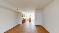 Located at 11054 Warwick Blvd in Newport News, VA, this two-story home offers a practical and well-organized layout across two floors. The main level features an open living area that flows seamlessly into a generously sized kitchen. The kitchen is outfitted with warm honey-toned oak cabinetry, granite-style countertops, white appliances including a range, built-in microwave, and refrigerator, along with a peninsula that provides additional prep and storage space. Hardwood flooring runs throughout both levels, lending a consistent, warm aesthetic to the entire home. A staircase connects the main level to the upper floor, where both bedrooms are located. The primary bedroom is a comfortable size, featuring two windows that bring in natural light and a double-door closet for ample storage. The second bedroom is cozy and well-proportioned with matching hardwood floors. The full bathroom includes a tub-shower combination, toilet, single vanity with storage, and a wall mirror, finished in clean white tones with tile flooring. The home's neutral color palette and hardwood floors throughout create a bright, cohesive living environment suitable for a variety of lifestyles.