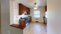Located at 1116 Randolph Ave in Saint Paul, MN, this single-floor unit offers a well-organized layout with consistent hardwood flooring connecting the main living areas. The living room is a bright, open space featuring warm hardwood floors, neutral-toned walls, and a window that draws in natural light and outdoor greenery views. A textured ceiling and radiant heating add to the room's character.

The kitchen is accessed via a pass-through opening from the living area, creating a connected feel between spaces. It is equipped with rich medium-toned wood cabinetry, granite-style countertops, a stainless steel gas range with an overhead ventilation hood, and a dishwasher. Large tile flooring, a ceiling fan with light fixture, and a window overlooking the exterior complete this functional space.

The bedroom features gleaming hardwood floors, corner windows for ample natural light, a ceiling fan, and a spacious double sliding-door closet offering generous storage. The bathroom includes a tiled tub-shower combination, classic mosaic tile flooring, a window for ventilation, and clean white walls throughout. The overall ambiance of the unit is practical and comfortable, suited to everyday living.