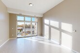 Located at 18248 W 12 Mile Rd in Southfield, Michigan, this 2-bedroom, 1-bathroom unit offers a well-organized, single-floor layout designed for comfortable everyday living. The open-concept living and dining area is a highlight of the space, featuring light wood-look flooring, warm neutral tones, and large floor-to-ceiling windows with transom panels that flood the room with natural light. A sliding glass door leads directly to a private balcony with outdoor views of the surrounding neighborhood. The kitchen is equipped with dark espresso cabinetry, granite countertops, and ample storage, flowing seamlessly into the main living area. Both bedrooms are carpeted and generously sized, with the primary bedroom offering a spacious walk-in closet with built-in wire shelving. A second closet is also available, providing additional storage. The full bathroom features large-format tile, a soaking tub with tiled surround, a dark wood vanity with granite countertop, and tile flooring. A dedicated laundry room and hallway complete the functional layout. Three closets throughout the unit ensure plentiful storage. The space presents a clean, modern aesthetic with consistent finishes throughout.