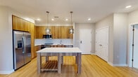 Located at 380 W Swedesford Rd in Berwyn, PA, this well-appointed single-floor home offers four bedrooms, two bathrooms, and a functional layout designed for everyday comfort. The kitchen is a standout feature, showcasing warm wood cabinetry that extends to the ceiling, crisp white quartz countertops, a subway tile backsplash, stainless steel appliances including a French door refrigerator, and light hardwood flooring that flows into the living area. Large windows in the living space fill the room with natural light and offer views of the surrounding greenery. The primary bedroom is generously sized and finished with plush carpeting, while additional bedrooms also feature soft carpet and neutral tones, providing a calm and versatile atmosphere. The primary bathroom includes a glass-enclosed walk-in shower with white subway tile and a wood-accented vanity, while the second bathroom offers a full soaking tub and shower combination with similar modern finishes. A dedicated walk-in closet with built-in wire shelving provides ample storage. The in-unit laundry room, accessible through louvered doors, houses a full-size side-by-side washer and dryer set atop hardwood flooring, adding a layer of everyday convenience to this thoughtfully designed home.