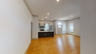 This two-story home offers a thoughtfully designed layout that balances open, communal living spaces with comfortable private retreats. The main floor features an open-concept living and kitchen area, where warm hardwood flooring flows throughout. The kitchen is well-equipped with stainless steel appliances — including a gas range, built-in microwave, and French door refrigerator — complemented by a dark-base island with a crisp white countertop, gray shaker cabinetry, and a matte black sink fixture. Recessed lighting illuminates the space, while multiple windows with blinds invite natural light. A dedicated laundry area is conveniently tucked just off the kitchen. The front entry features a paneled door with a transom window, adding architectural character to the welcoming foyer. Upstairs, the bedrooms are highlighted by vaulted ceilings with ceiling fans and bright windows. A spacious walk-in closet with wire shelving provides ample storage. The bathroom is elegantly finished with a double-sink vanity, large mirrors, light tile flooring, and a glass-enclosed tub-shower combination. Throughout, the home maintains a clean, neutral palette that lends itself to a modern and functional living experience.